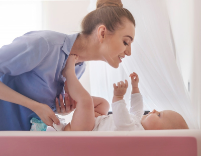 Professional newborn caregiver assisting parents with infant care at home