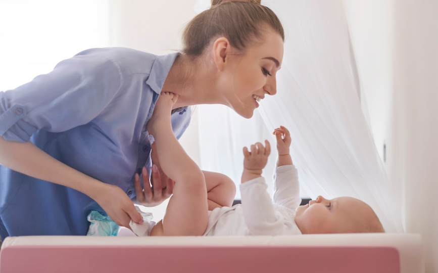 Professional newborn caregiver assisting parents with infant care at home